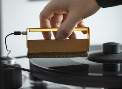 Pro-Ject Brush It Premium being used to clean a record with the earthing wire attached to remove any electrostatic charge on the record