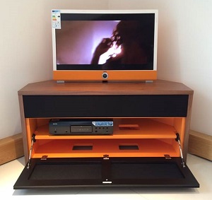 Audio Cabinet Tamzin Corner Unit. Soundbar aperture covered, pull down door open. Walnut cabinet shown with Black grille cloth and orange coloured internals.